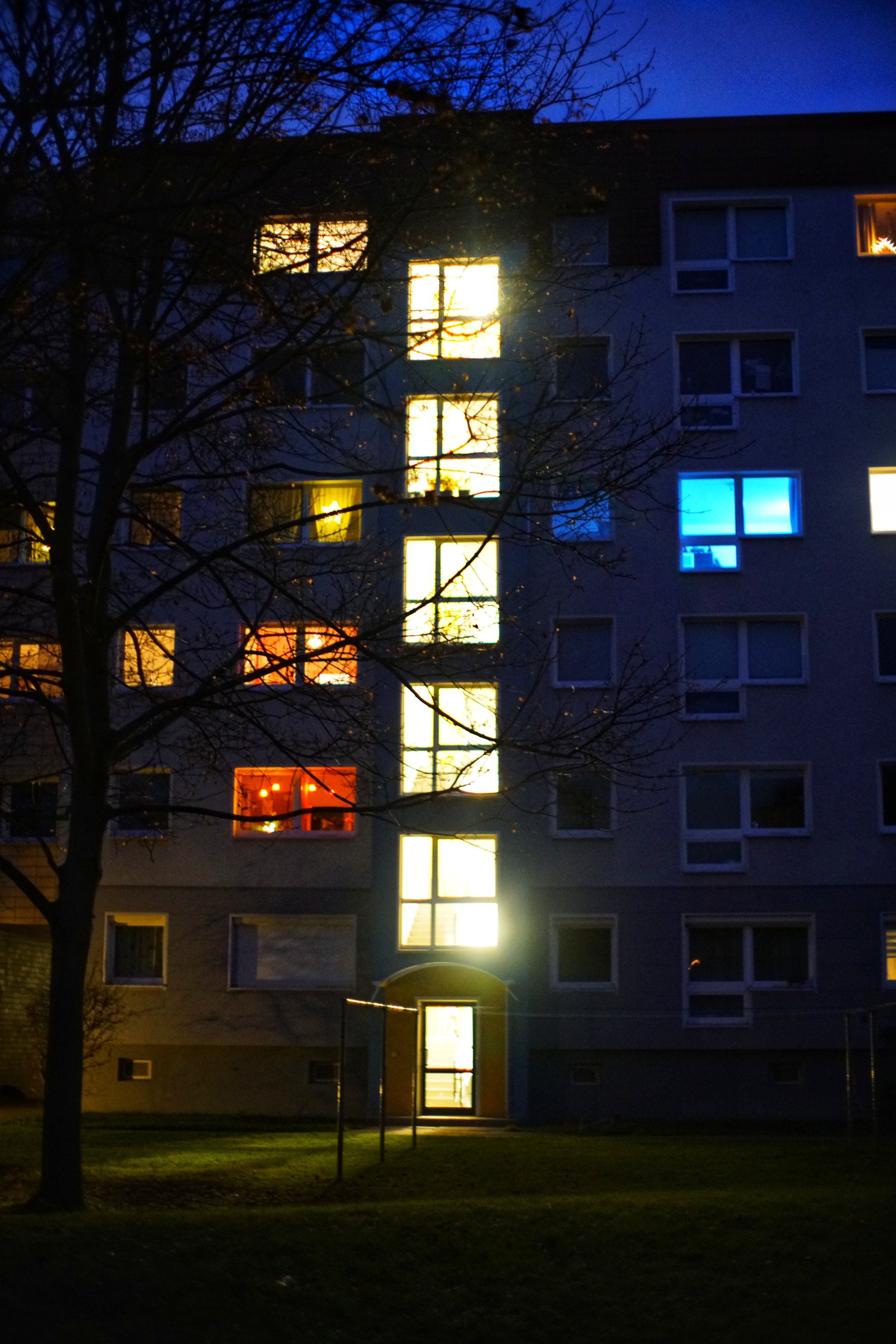 Beleuchtung im Treppenhaus, einzelne Fenster rechts/links davon ebenfalls erleuchtet 