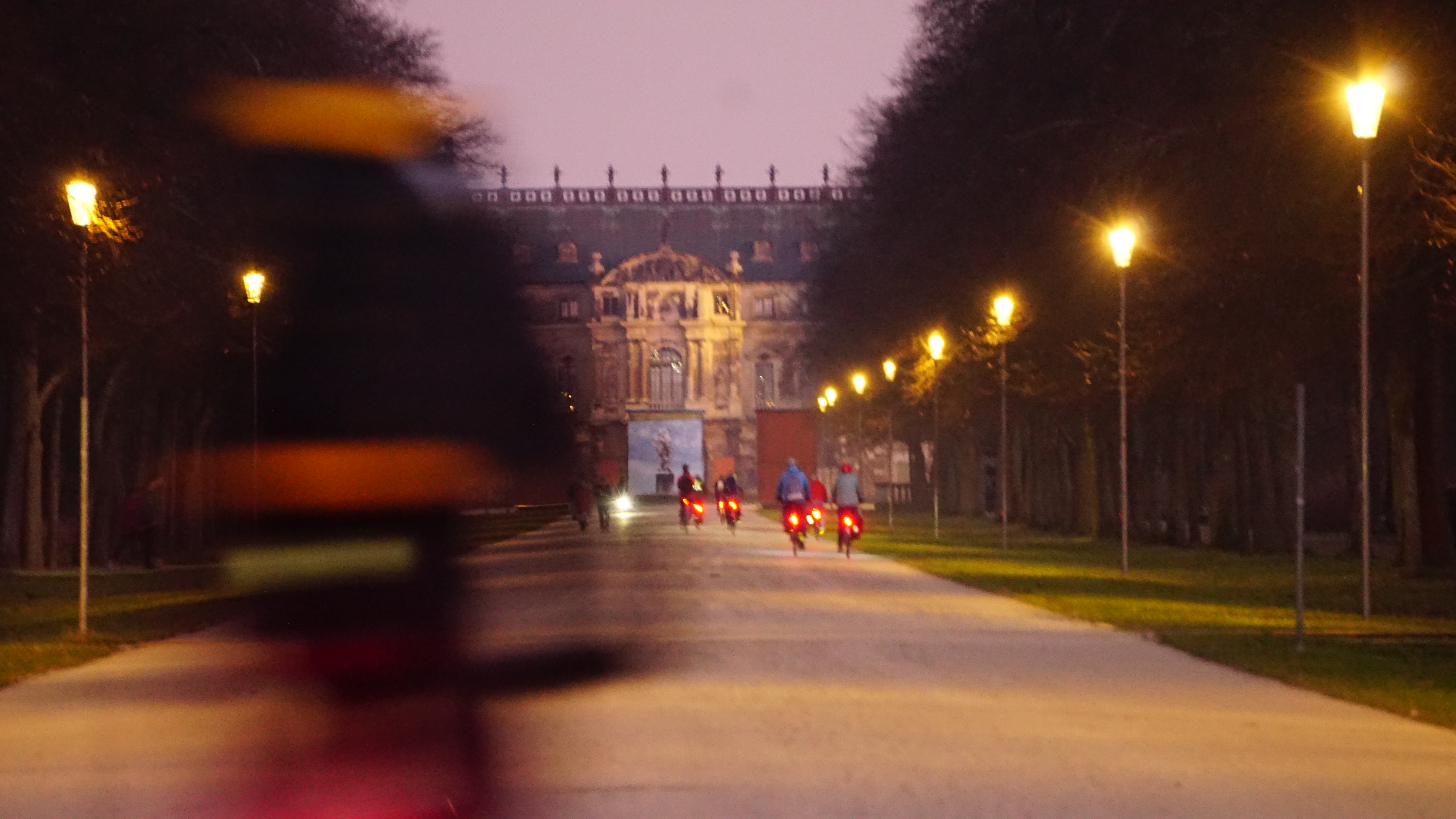 wieder die Hauptallee gen Palais, aber mit verwischtem Radfahrer im Vordergrund