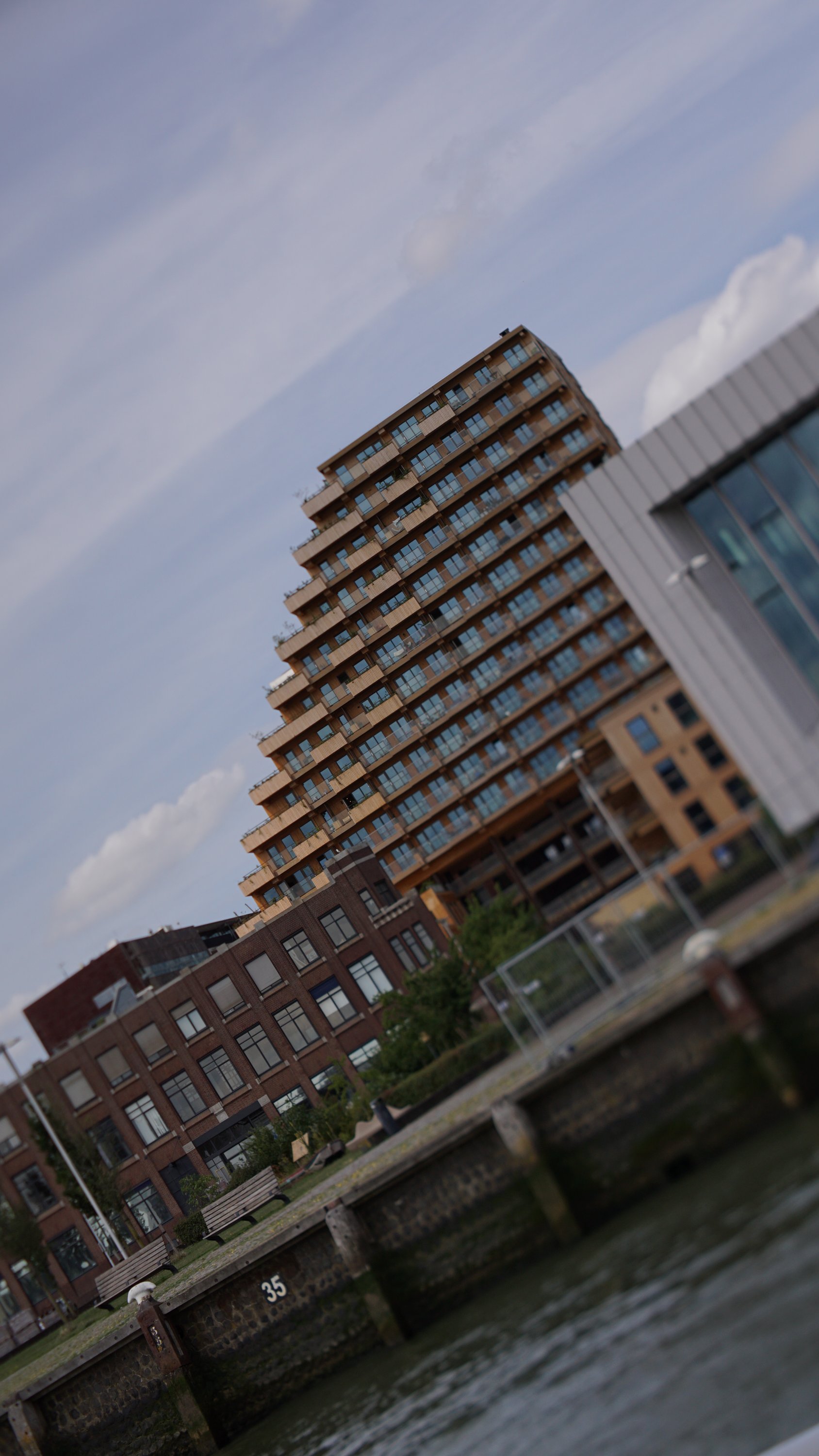 Treppenförmiges Gebäude, schräges Bild, Vertikale Achsen läuft diagonal 
Tilt-Ebene auf die "Treppe" gelegt, Rest des Bildes daher unscharf 
Pier im Vordergrund, eine 35 an selbigem ist ebenfalls scharf