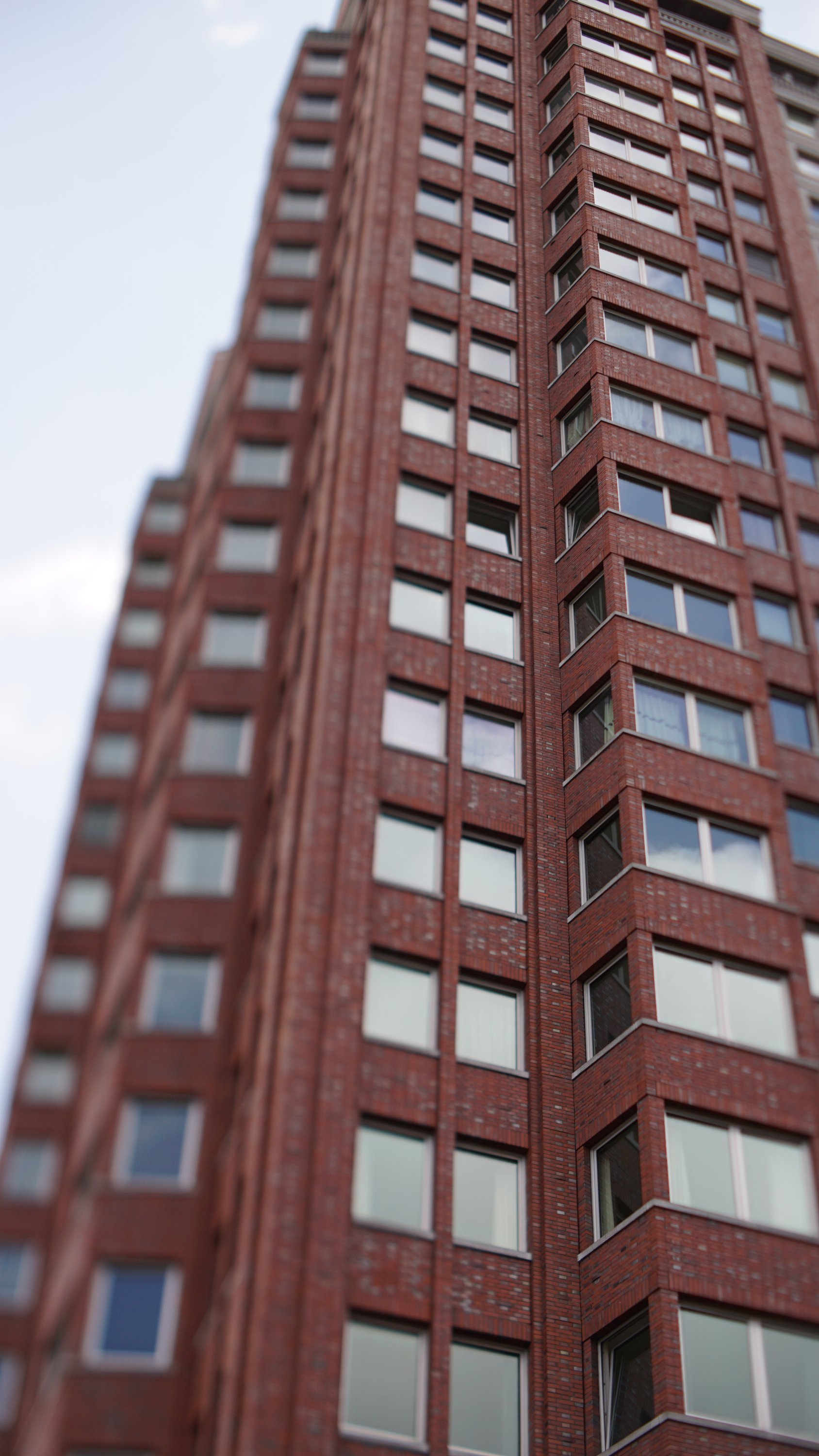 Rotes Hochhaus in Ziegel-Optik, erneut die Tilt-Ebene entlang der vertikalen Ecke des Gebäudes 