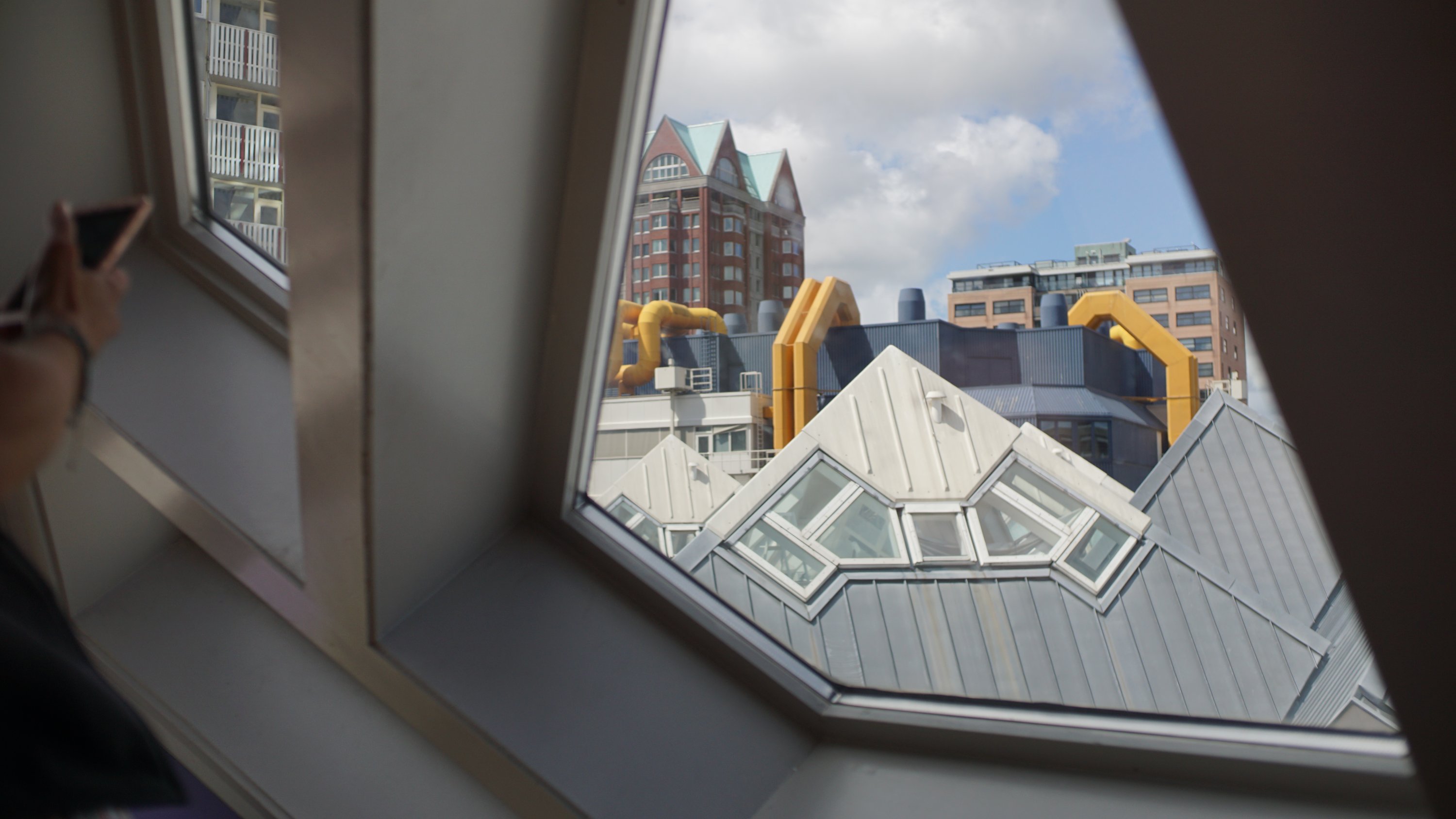 Blick aus einem schrägen Fenster über andere Würfelhäuser, Richtung Bibliothek 