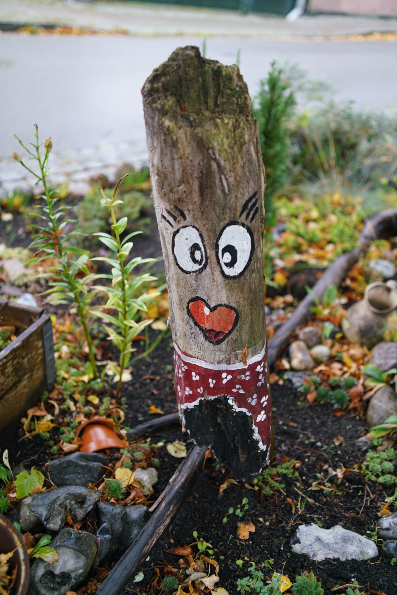 Ein bemalter Baumstumpf mi Gesicht 