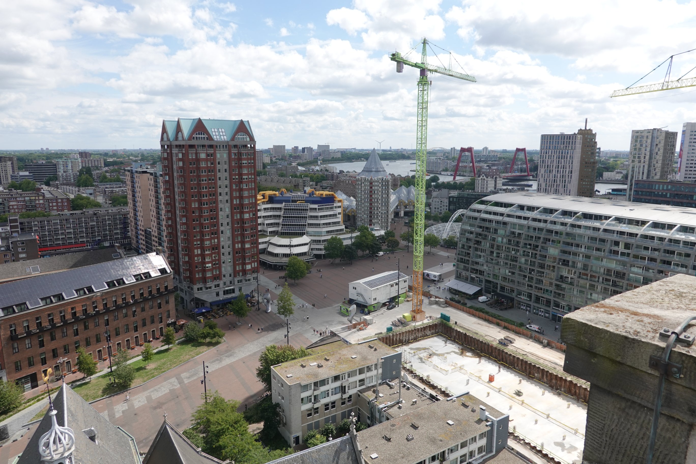 Markthalle rechts, Würfelhäuser, Bibliothek und schwarzer Turm in der Mitte 

Davor grüner Kran
R
Links anderes Hochhaus 
Unten am Bildschirmrand Reste vom Dach der Kirche 