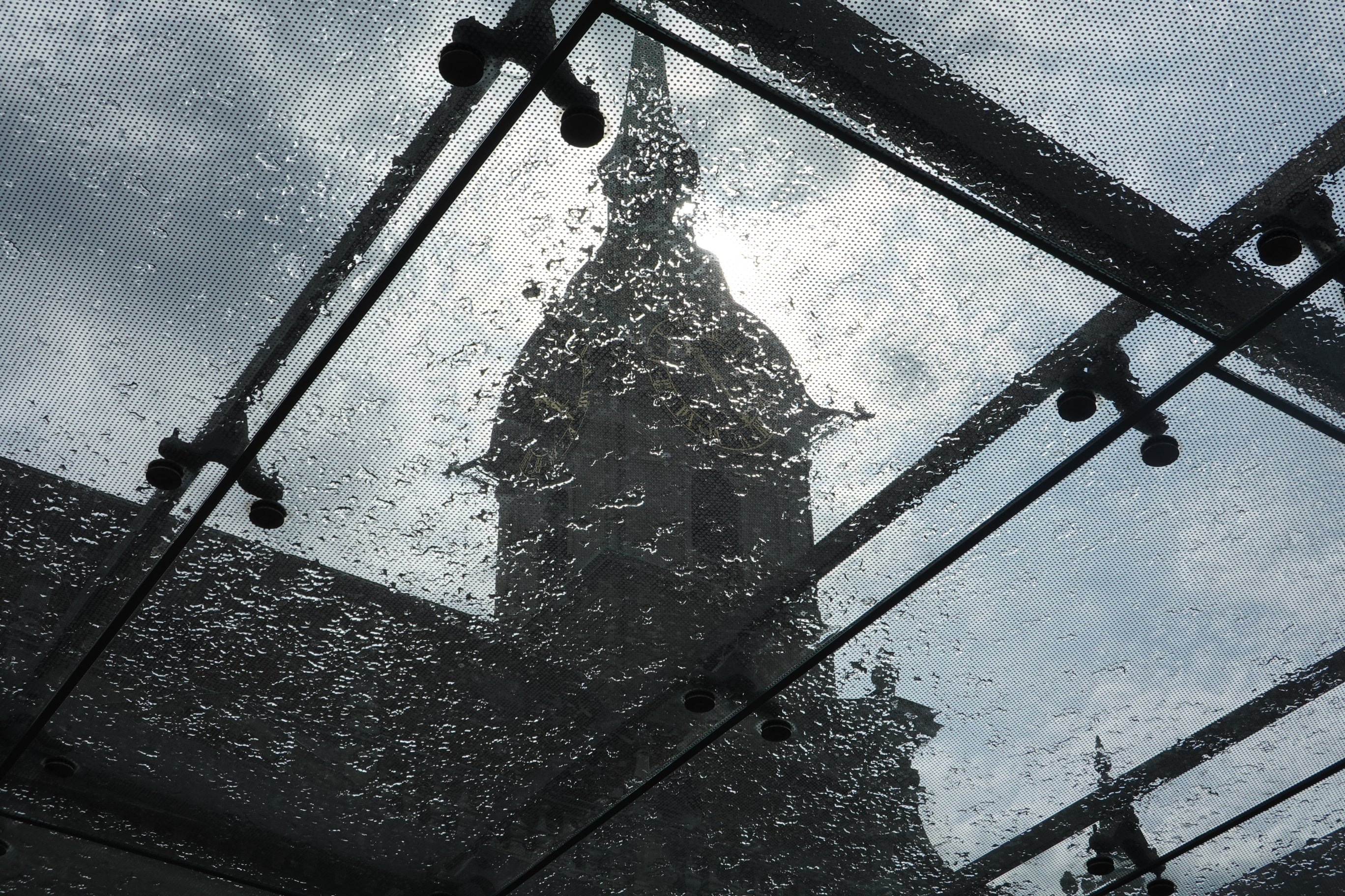 Sun behind church/clouda, behind glas roof (with water) of tram station