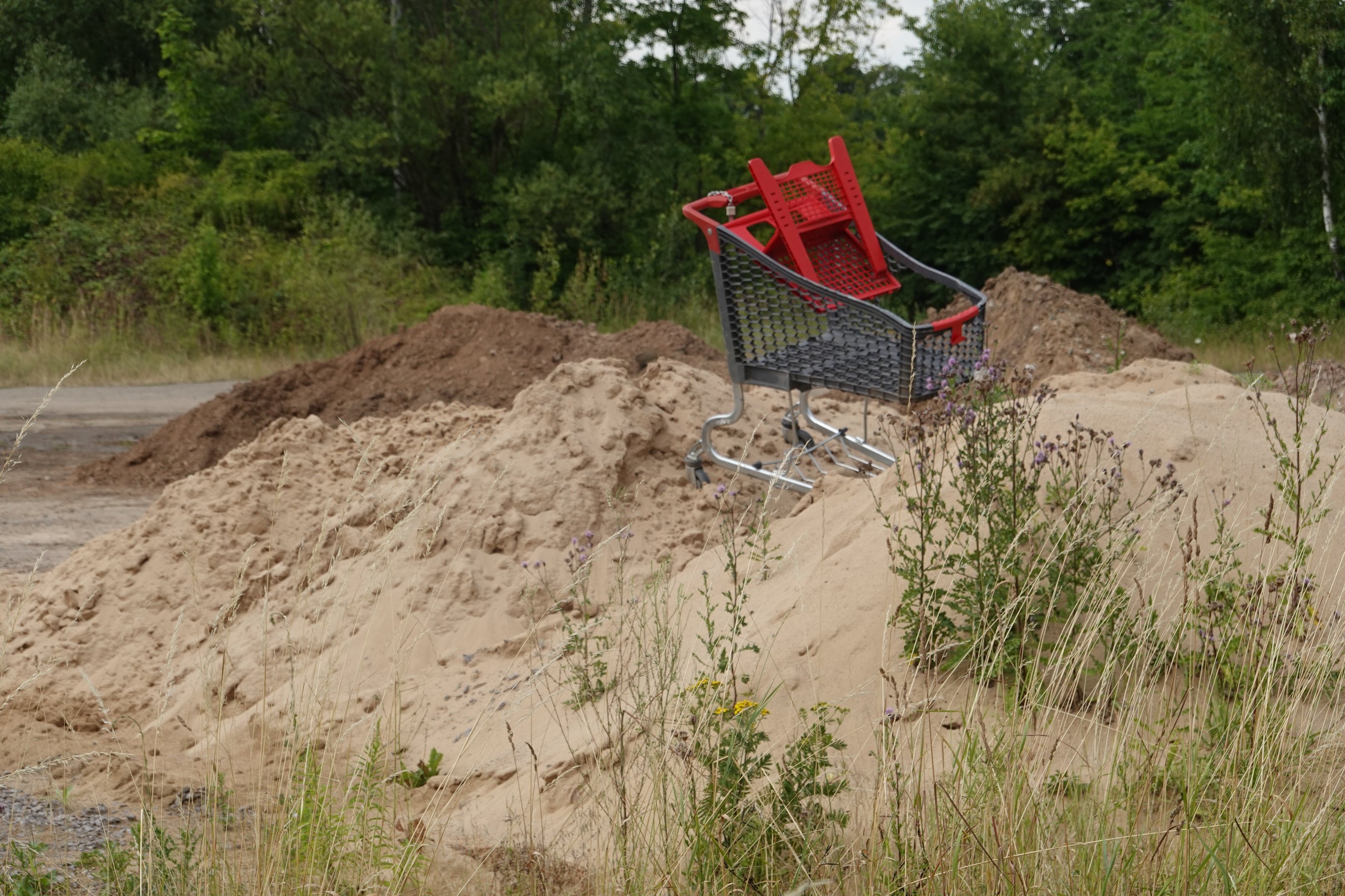 Ein Einkaufswagen auf einem Sandhaufen 