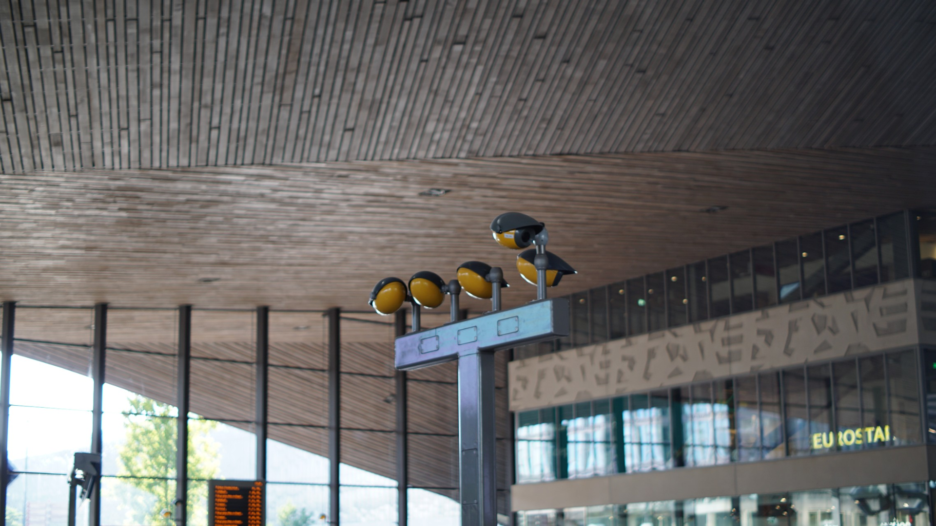 a couple of orange video cameras inside of the main station of rotterdam a couple of orange video cameras inside of the main station of rotterdam