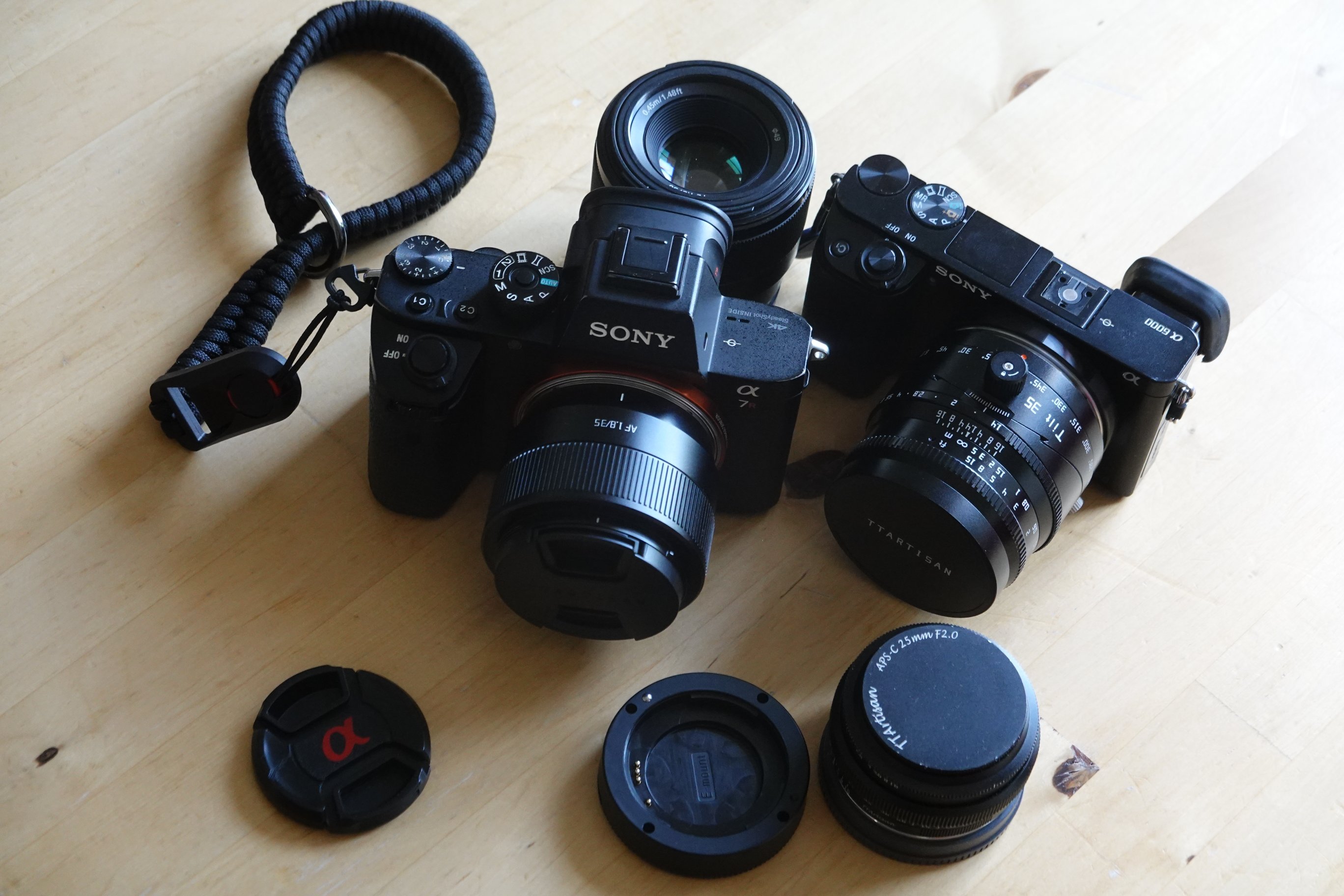 Zwei Sony Alpha Kameras, mit 4 Objektiven

- TTArtisan 35mm jeweils an den Kameras montiert (AF Version 2 an der Alpha7, das manuelle Tilt an der 6000er)
- TTArtisan 25mm F2 steht davor 
- Sony 50mm F1.i offen dahinter 