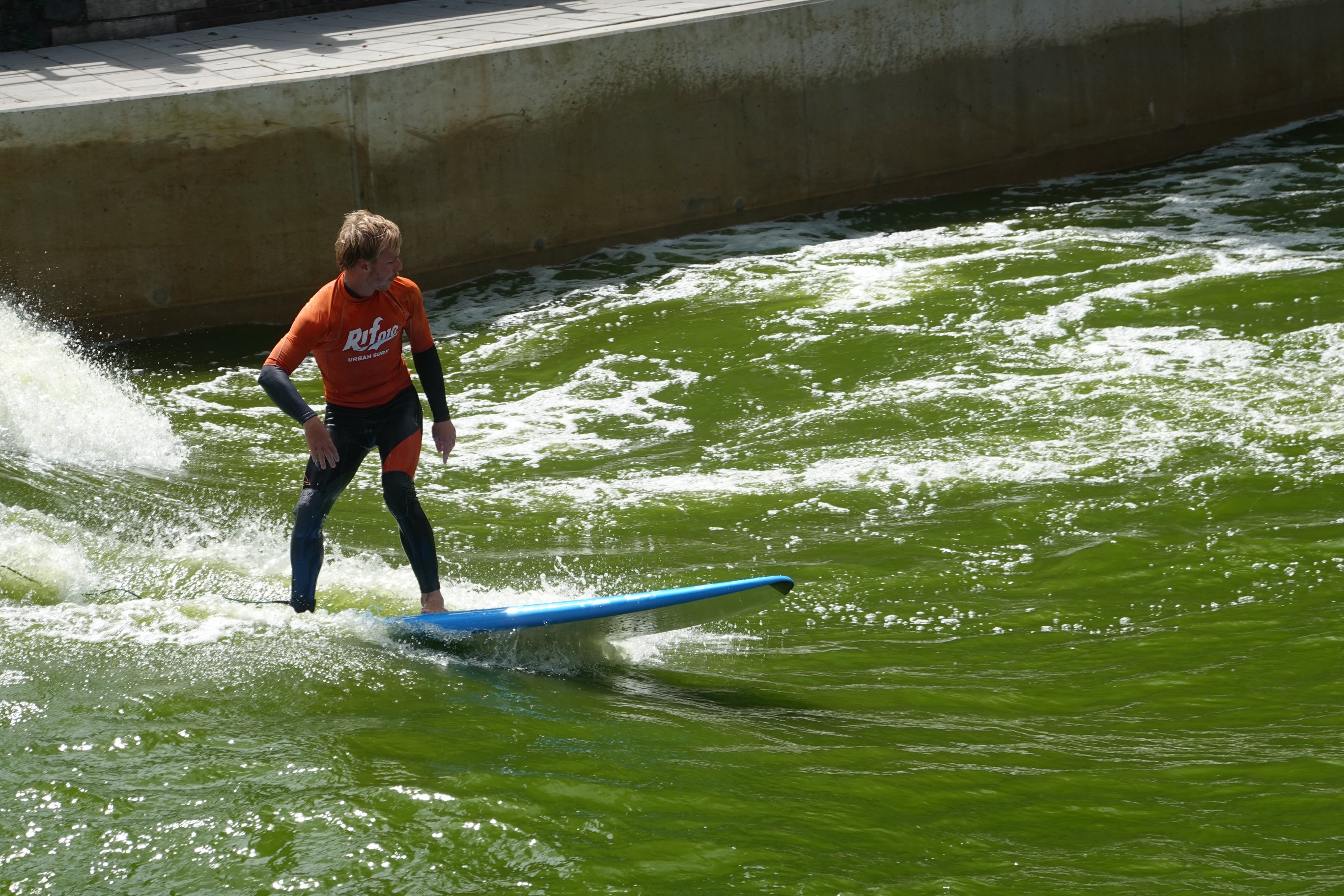 Surfer auf Welle in grünem Wasser 