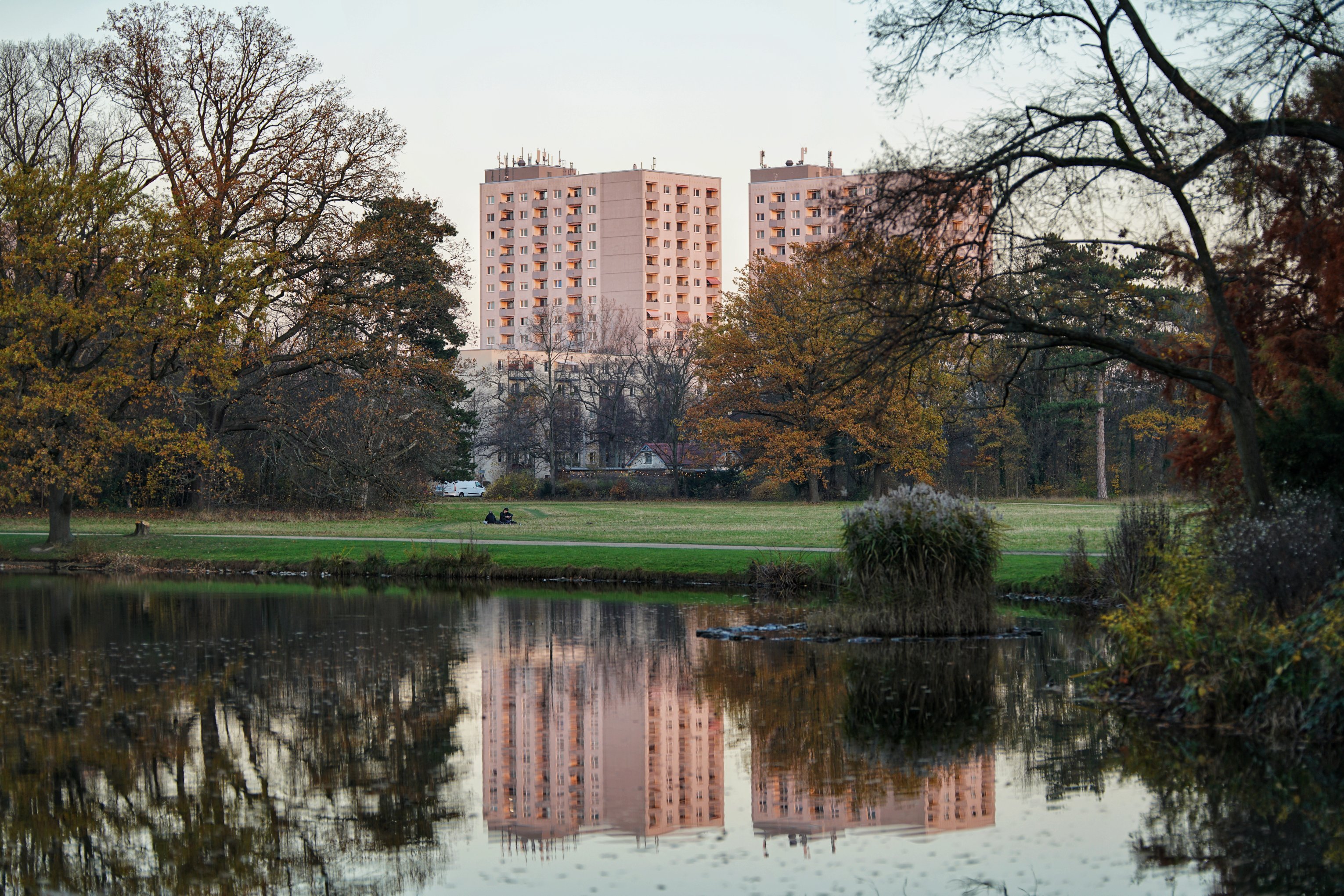Teich in dem sich Wohntürme spiegeln