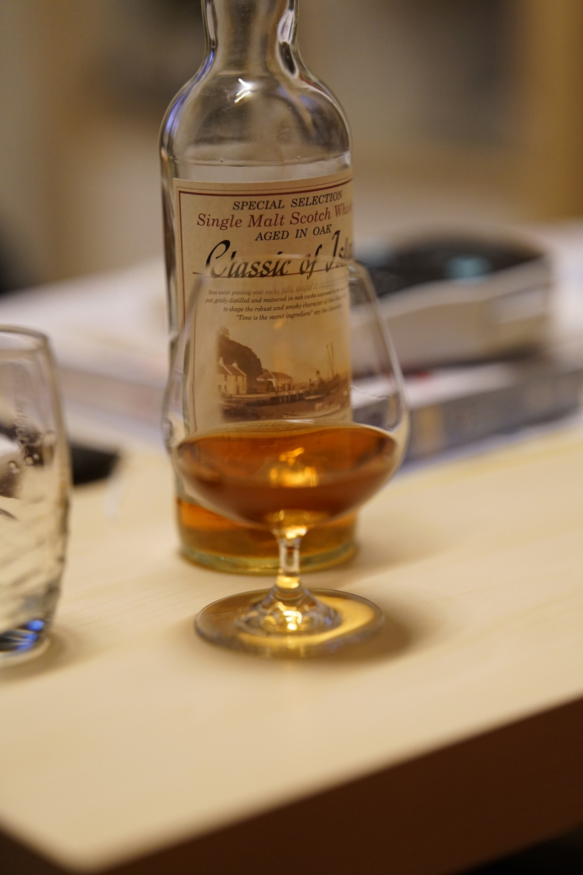 fast leere Flasche Whisky, gut gefüllter Cognacschwenker davor