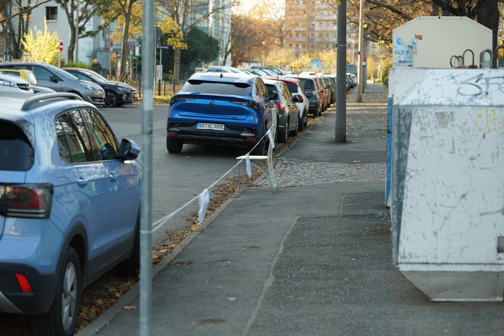 Fußweg künstlich verengt weil da Container drauf stehen… unmittelbar vor einer stark frequentierten Kreuzung zu Fuß-/Radweg, was eh schon immer kritisch ist?

Jemand hat die Ecke nochmal weiter verengt indem er einen Stuhl drauf stellte und für einen Umzug blockierte.

…man hätte das auch auf der Fahrbahn tun können, da ist eh Parkverbot?