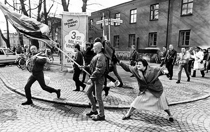 Das bei Wikipedia beschriebene Bild:

Die Frau mit der Handtasche (schwedisch Kvinnan med handväskan, auch Tanten med handväskan) ist eine Fotografie, die der Fotojournalist Hans Runesson am 13. April 1985 im schwedischen Växjö aufnahm. Sie zeigt eine Frau, Danuta Danielsson, die einen Neo-Nazi mit einer Handtasche schlägt.[1] 

