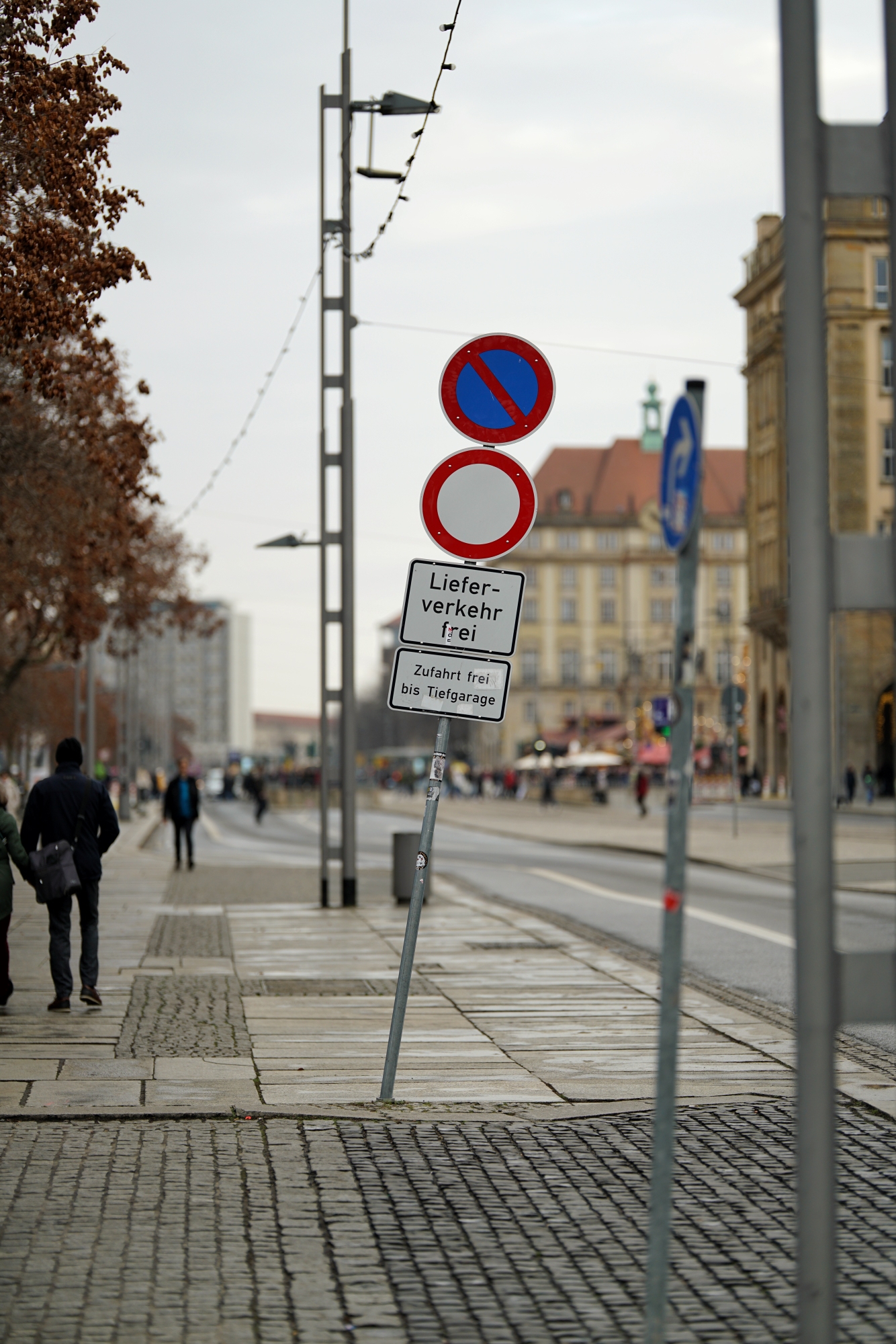 ein Parkverbot/Vollsperrscheibe mit "Kieferverkehr frei" und "Zufahrt frei bis Tiefgarage", stark geneigt und entgegen der Fahrtrichtung verdreht 

im Hintergrund Striezelmarkt, stark unscharf