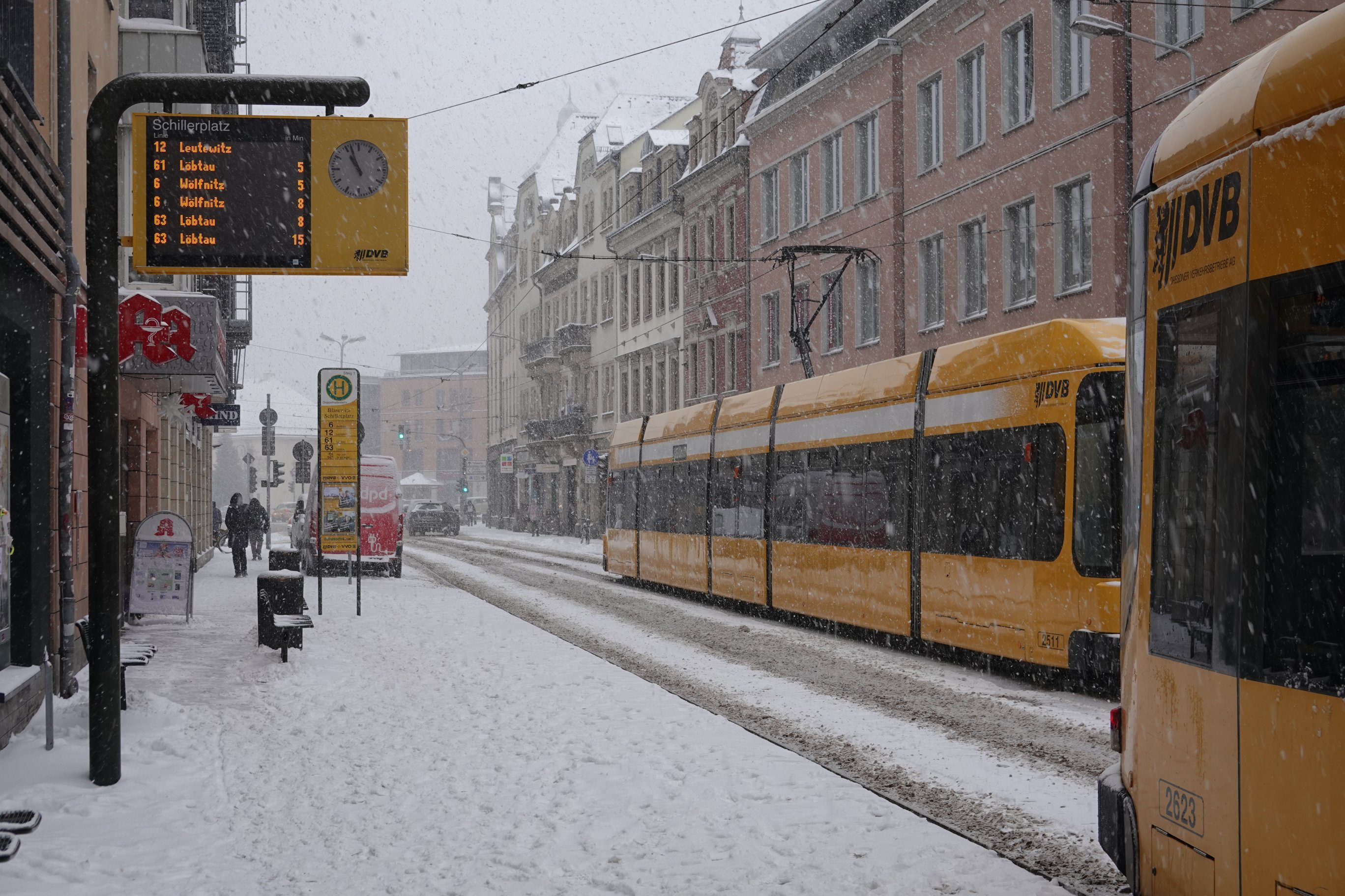 Weitwinkeliger, man sieht auch Haltestellenschild und mehrere Straßenbahnen