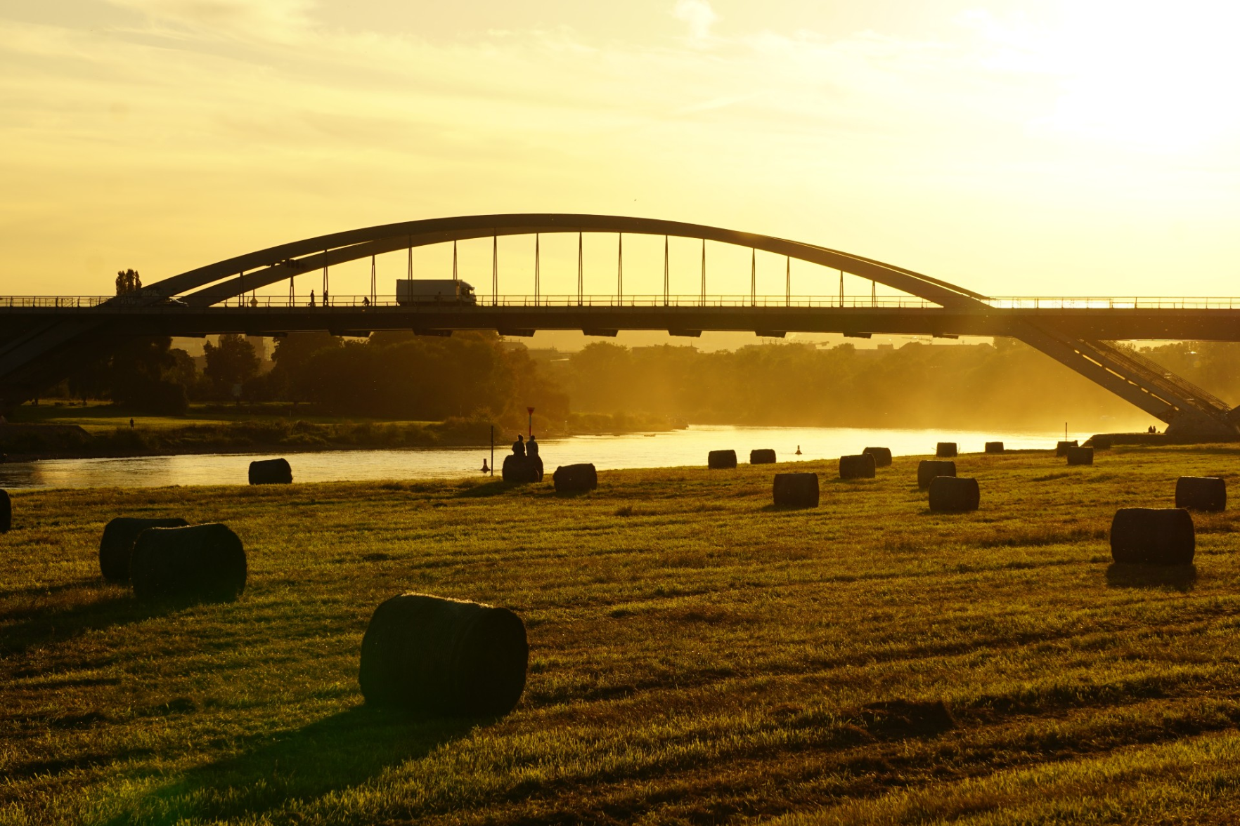 Heuballen auf den Elbwiesen, Sonne scheint durch den Staub der Mäher unter der Waldschlößchenbrücke hindurch Heuballen auf den Elbwiesen, Sonne scheint durch den Staub der Mäher unter der Waldschlößchenbrücke hindurch